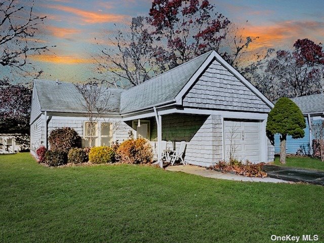 145 Edinburgh Drive, Unit 145 Ridge, NY 11961 - Photo 2 of 18 a front view of a house with a yard table and chairs