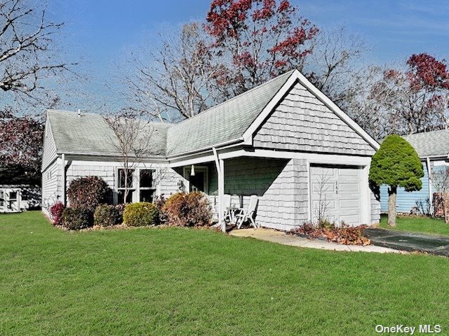 145 Edinburgh Drive, Unit 145 Ridge, NY 11961 - Photo 3 of 18 a front view of a house with garden