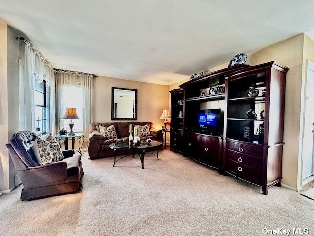 145 Edinburgh Drive, Unit 145 Ridge, NY 11961 - Photo 8 of 18 a living room with furniture and a flat screen tv