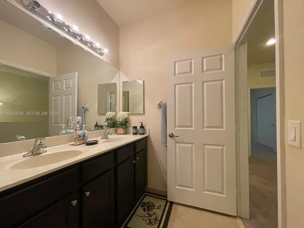 a bathroom with a double vanity sink and a mirror