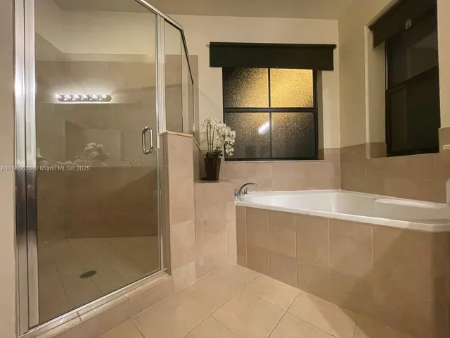 a spacious bathroom with a double vanity sink a large mirror and a bathtub