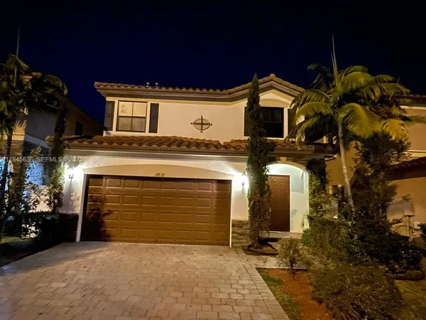 a spacious bedroom with a bed and a lamp on table