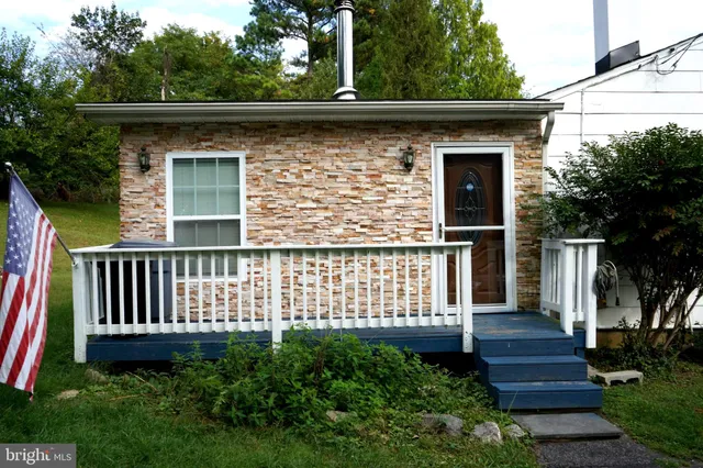 a view of a house with a small yard and wooden floor and fence