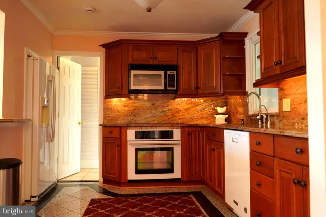 a kitchen with stainless steel appliances granite countertop a stove microwave and refrigerator