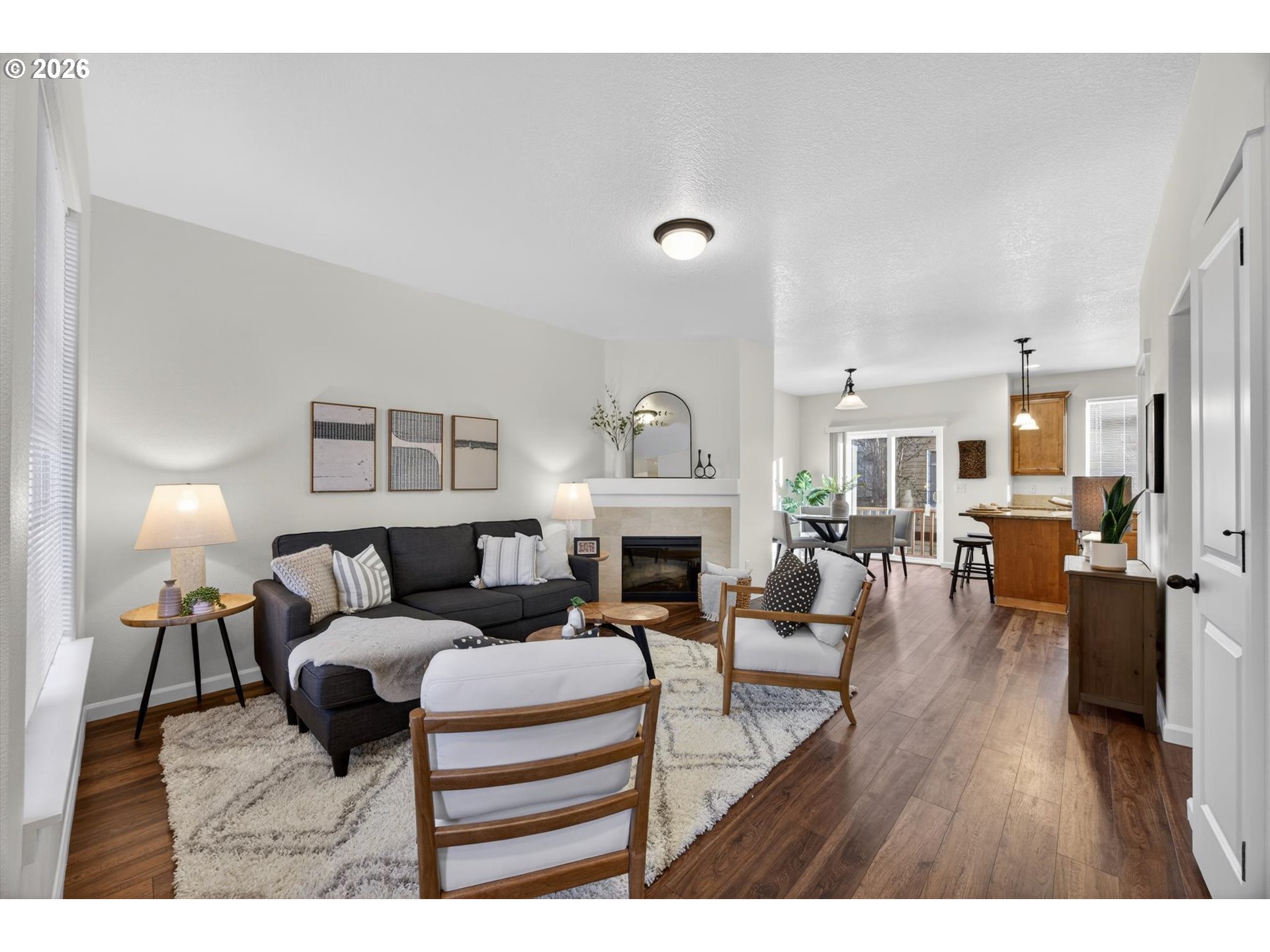 16260 Southwest Mason Lane Beaverton, OR 97006 - Photo 5 of 41 a living room with furniture a fireplace and a dining table with wooden floor