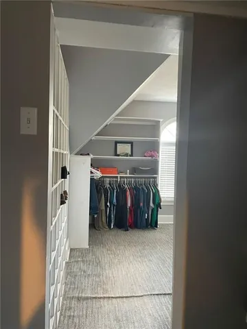 a view of walk in closet with clothes