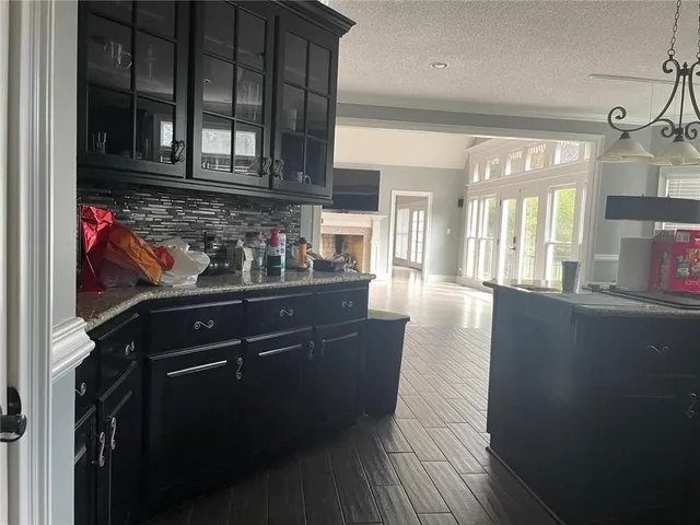 a kitchen with stainless steel appliances granite countertop a refrigerator a stove and a wooden floors