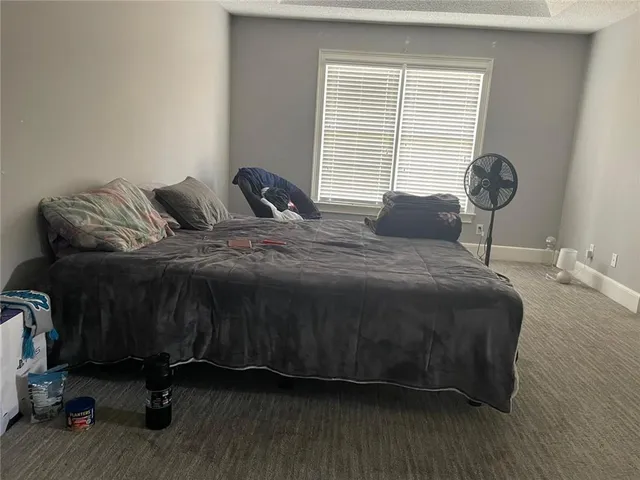 a bed sitting in a bedroom next to a window