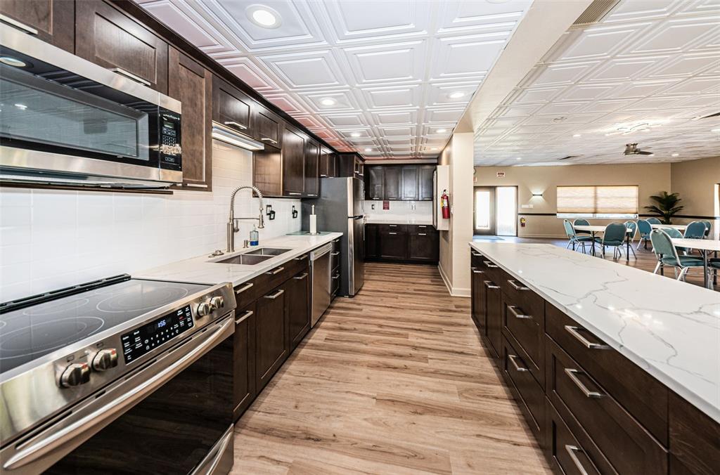 1 Boca Ciega Point Boulevard, Unit 314 St. Petersburg, FL 33708 - Photo 47 of 89 a large kitchen with stainless steel appliances granite countertop a large stove a sink dishwasher and cabinets with wooden floor