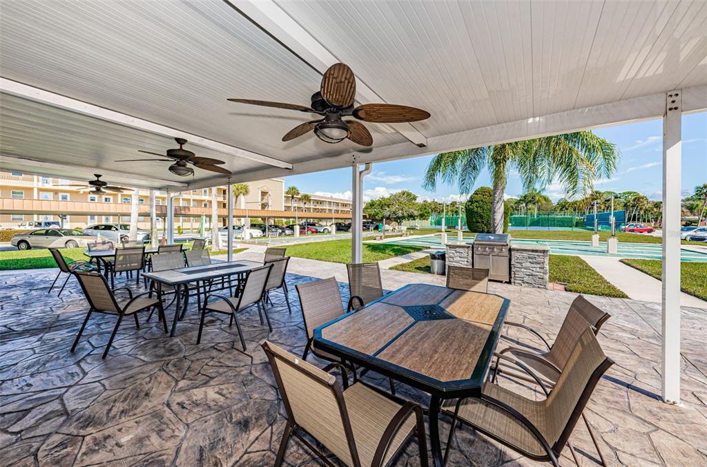 1 Boca Ciega Point Boulevard, Unit 314 St. Petersburg, FL 33708 - Photo 55 of 89 a view of a patio with a table chairs and a small yard