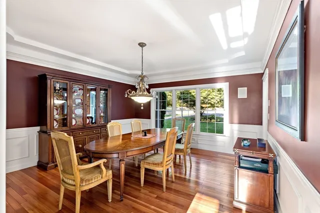 a dining room with furniture a chandelier and wooden floor