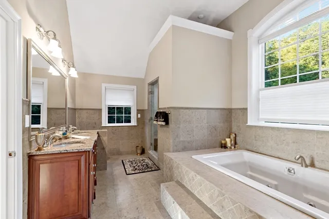 a bathroom with a tub sink and mirror