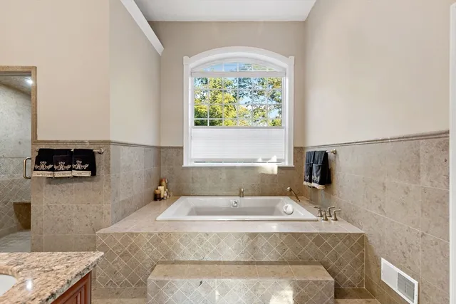 a bathroom with a granite countertop sink and a window