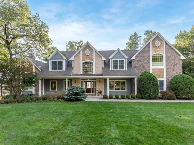 a front view of a house with a yard and potted plants