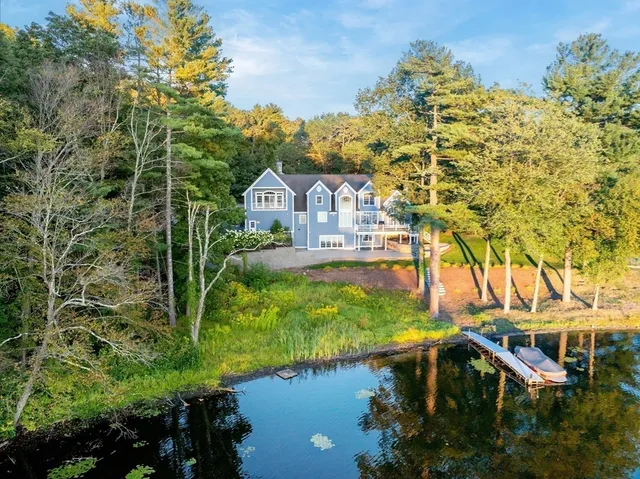 a view of a house with a yard next to a lake
