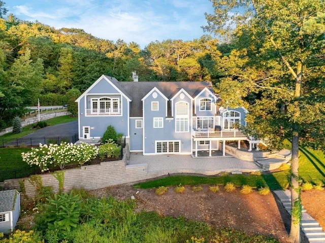 a view of a big house with a big yard and potted plants