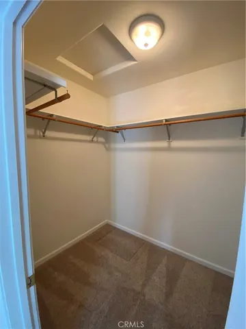 a view of a big room with chandelier fan and windows