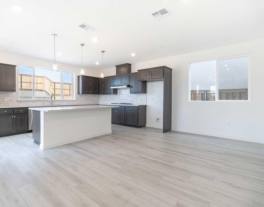 312 West Pasqua Glen Mountain House, CA 95391 - Photo 6 of 16 a large kitchen with kitchen island a stove a sink dishwasher a refrigerator and white cabinets with wooden floor