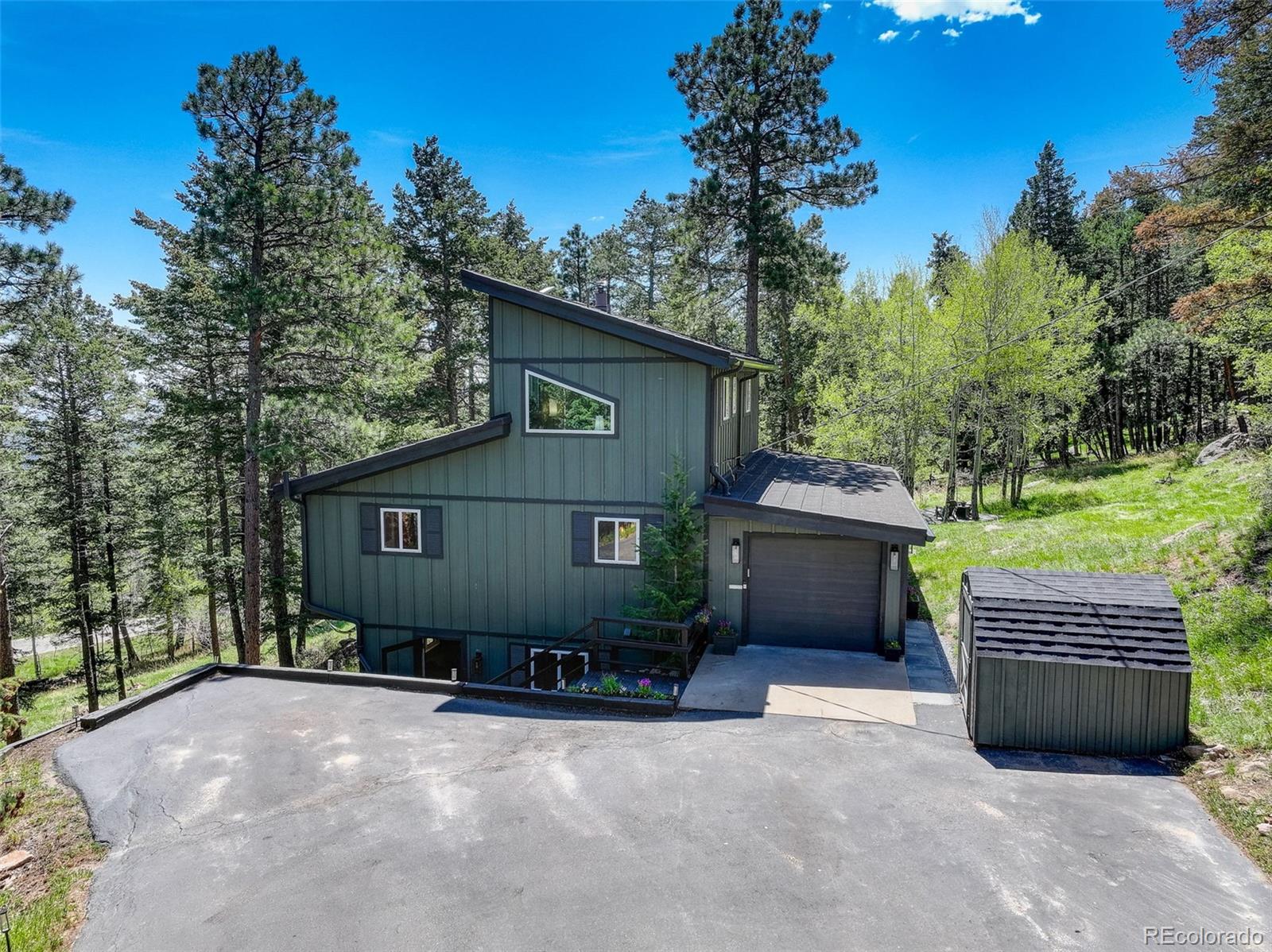 8515 Doubleheader Ranch Road Morrison, CO 80465 - Photo 1 of 42 a front view of a house with a yard and garage
