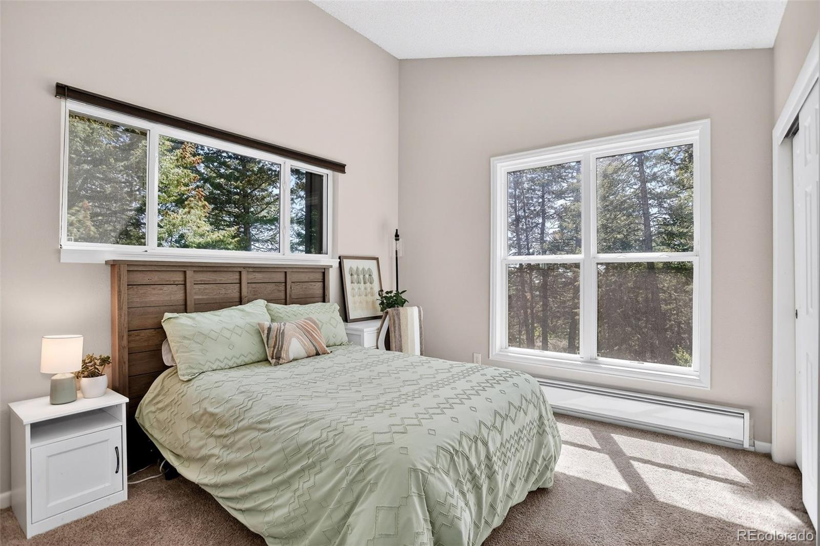 8515 Doubleheader Ranch Road Morrison, CO 80465 - Photo 24 of 42 a bedroom with a large bed and a large window
