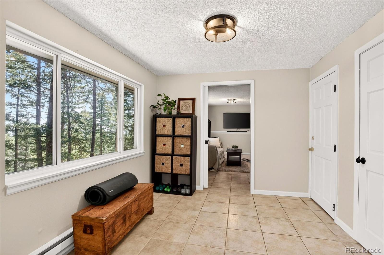 8515 Doubleheader Ranch Road Morrison, CO 80465 - Photo 28 of 42 a living room with furniture and a floor to ceiling window