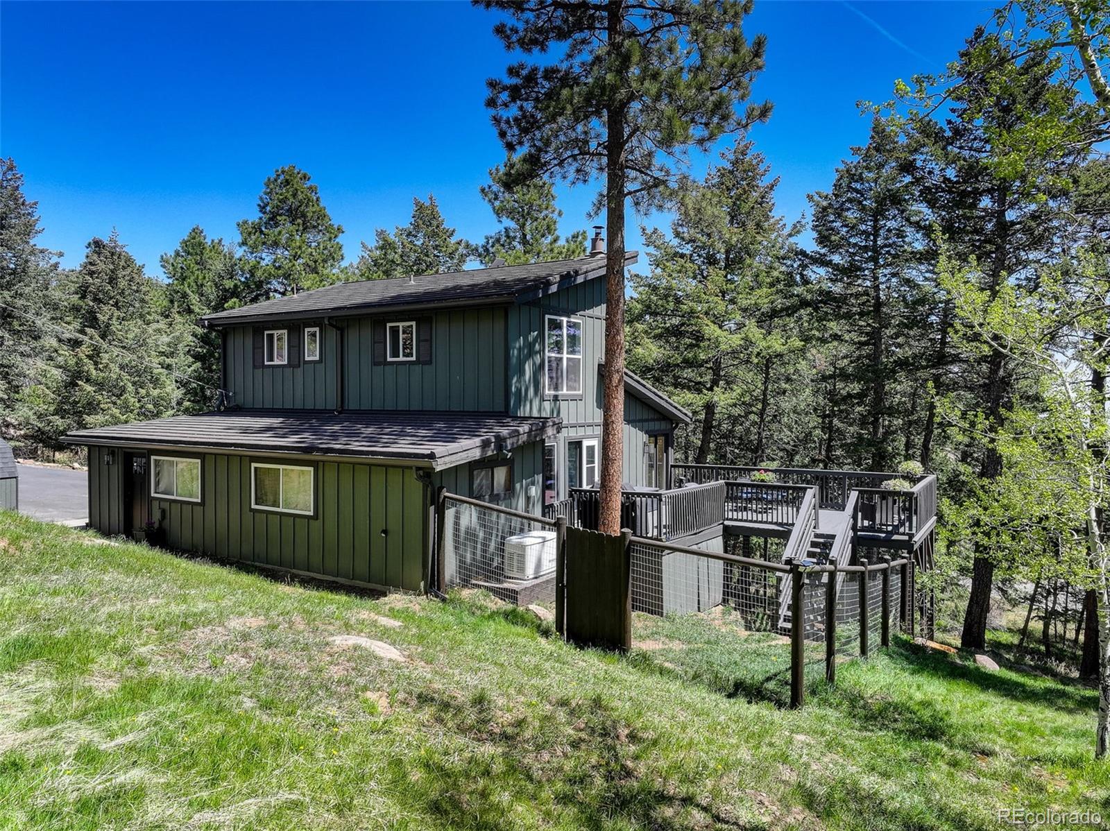 8515 Doubleheader Ranch Road Morrison, CO 80465 - Photo 42 of 42 a front view of a house with a garden