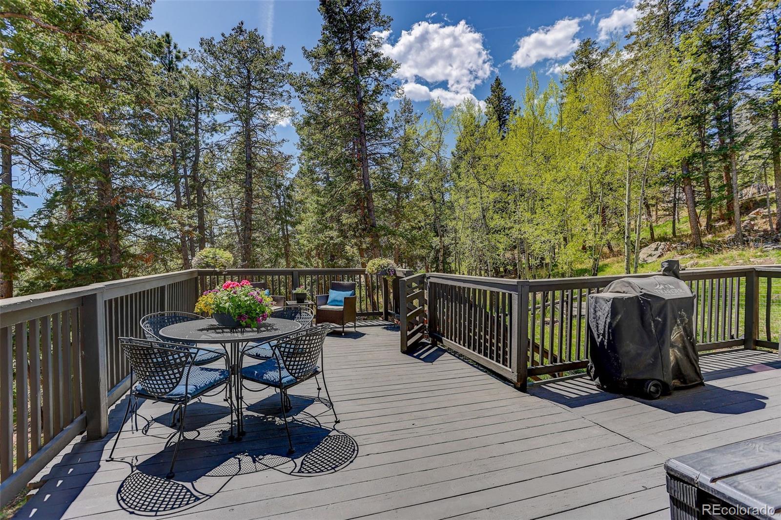 8515 Doubleheader Ranch Road Morrison, CO 80465 - Photo 6 of 42 a balcony with wooden cabinets and outdoor seating