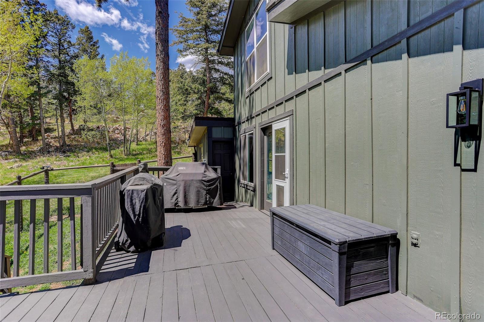 8515 Doubleheader Ranch Road Morrison, CO 80465 - Photo 7 of 42 a view of a deck with wooden floor and seating space