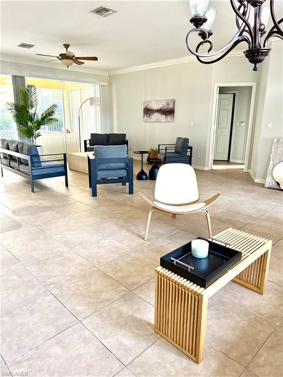 14530 Indigo Lakes Circle Naples, FL 34119 - Photo 2 of 18 a living room with furniture a window and a chandelier