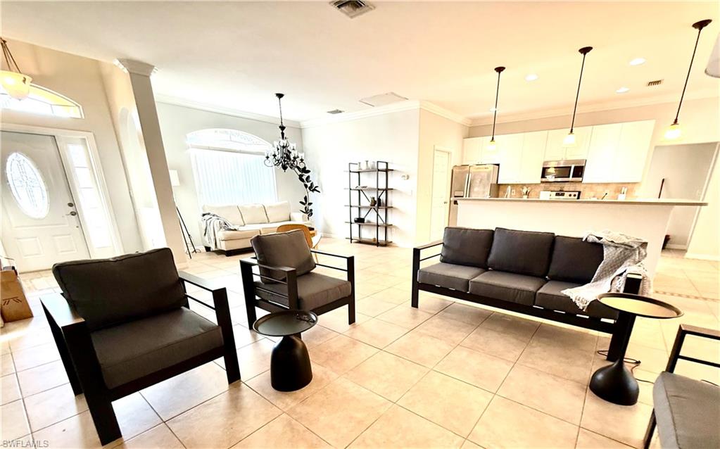 14530 Indigo Lakes Circle Naples, FL 34119 - Photo 4 of 18 a living room with furniture and a chandelier