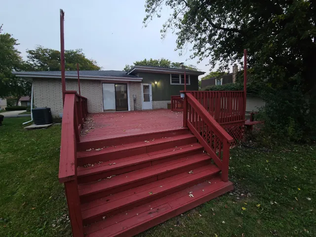 a view of a house with a yard balcony and wooden fence