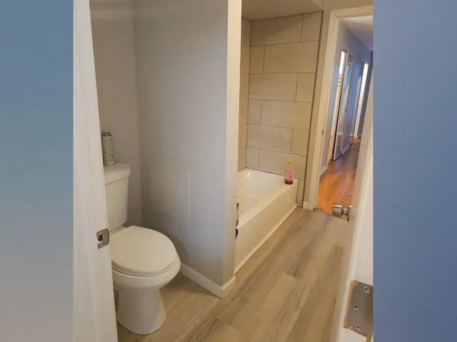 a bathroom with a granite countertop bathtub and toilet
