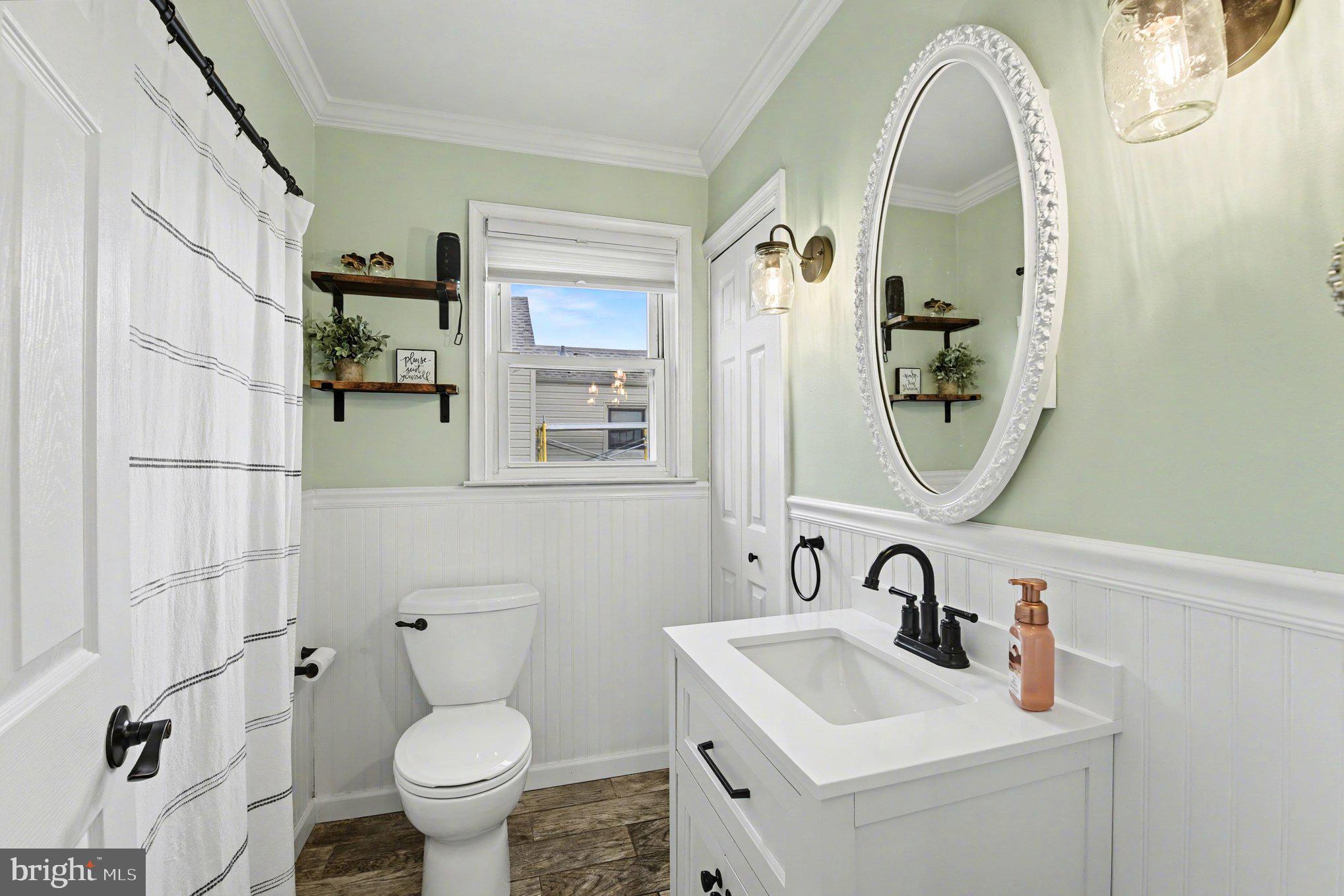 6807 North Point Road Sparrows Point, MD 21219 - Photo 15 of 28 a bathroom with a toilet sink and mirror