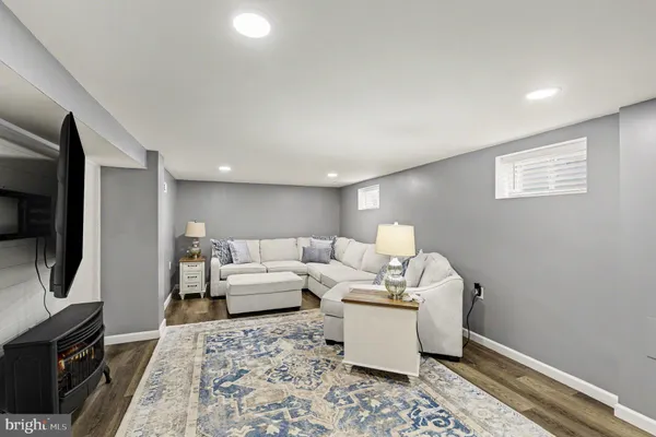 a living room with furniture a flat screen tv and a rug