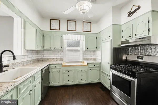 a kitchen with stainless steel appliances a sink stove and cabinets