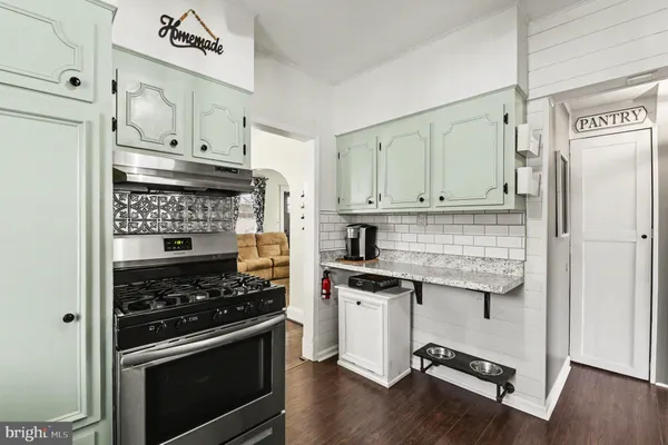 a kitchen with granite countertop cabinets stainless steel appliances and wooden floor