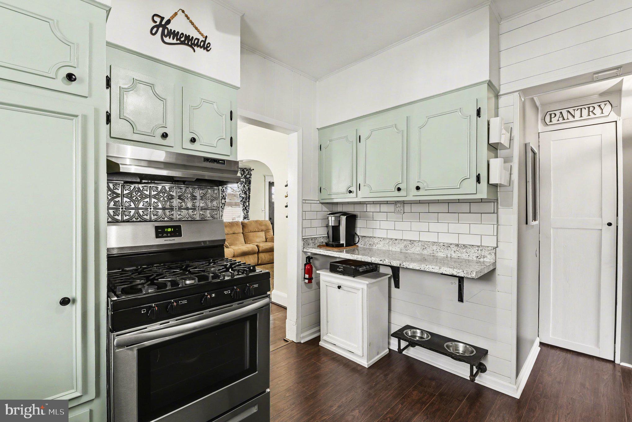 6807 North Point Road Sparrows Point, MD 21219 - Photo 9 of 28 a kitchen with granite countertop cabinets stainless steel appliances and wooden floor