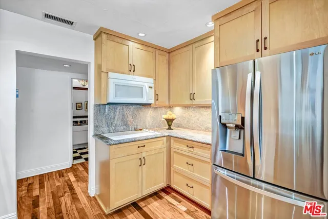 a kitchen with stainless steel appliances a refrigerator sink and microwave
