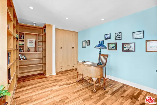 a workspace room with wooden floor and furniture