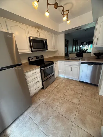 a kitchen with stainless steel appliances a refrigerator sink microwave and cabinets