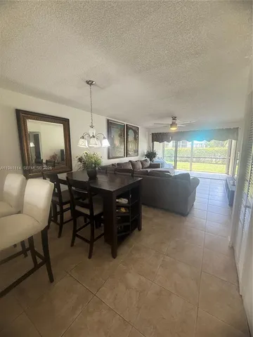 a living room with furniture and a dining table with kitchen view