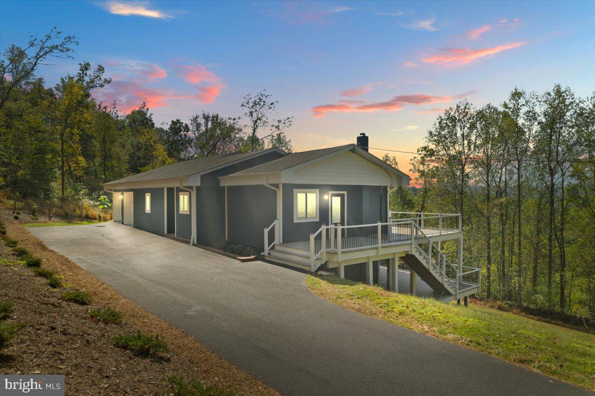 a view of a house with a yard and large trees