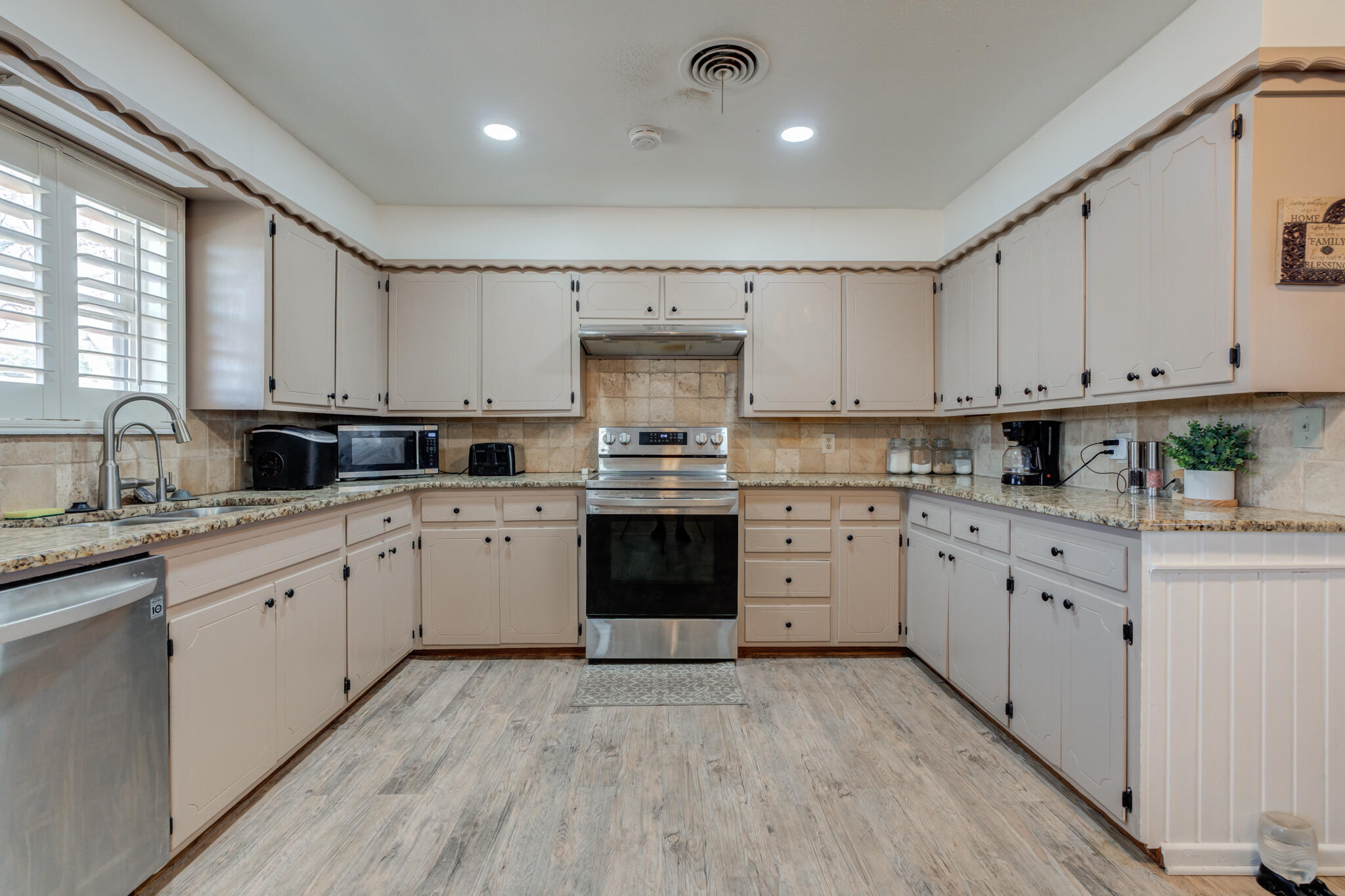 2141 71st Street Lubbock, TX 79412 - Photo 11 of 36 a kitchen with granite countertop white cabinets white stainless steel appliances with a sink and dishwasher