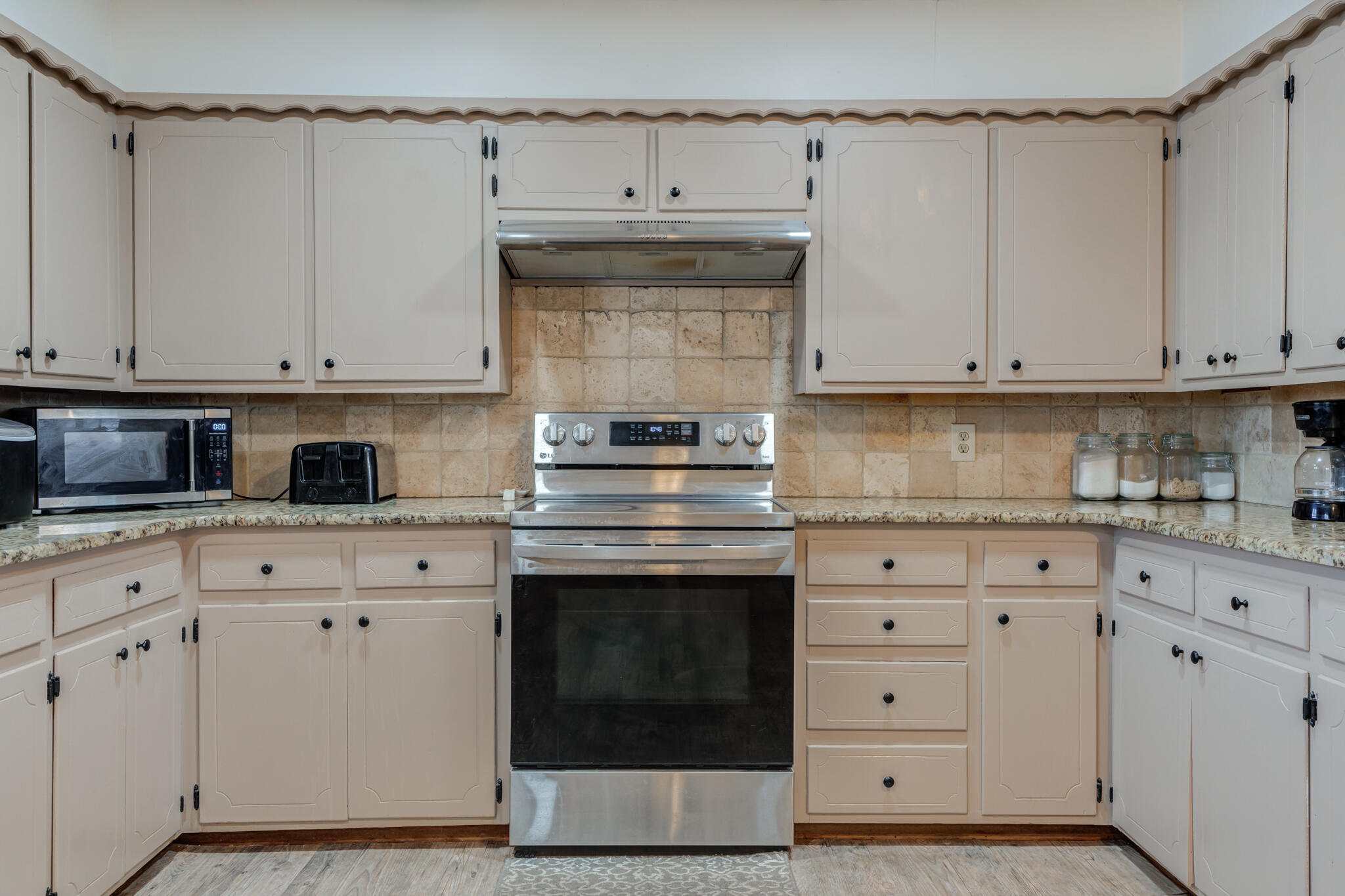 2141 71st Street Lubbock, TX 79412 - Photo 12 of 36 a kitchen with granite countertop white cabinets and white stove