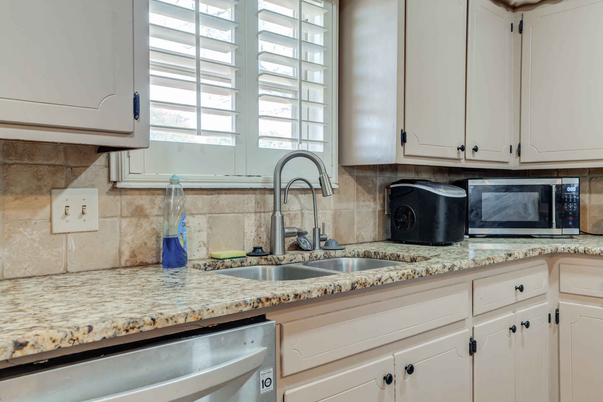 2141 71st Street Lubbock, TX 79412 - Photo 13 of 36 a kitchen with granite countertop white cabinets and a sink