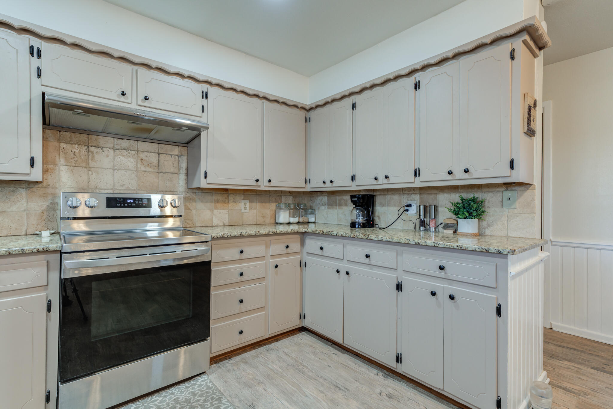 2141 71st Street Lubbock, TX 79412 - Photo 14 of 36 a kitchen with granite countertop white cabinets and stainless steel appliances
