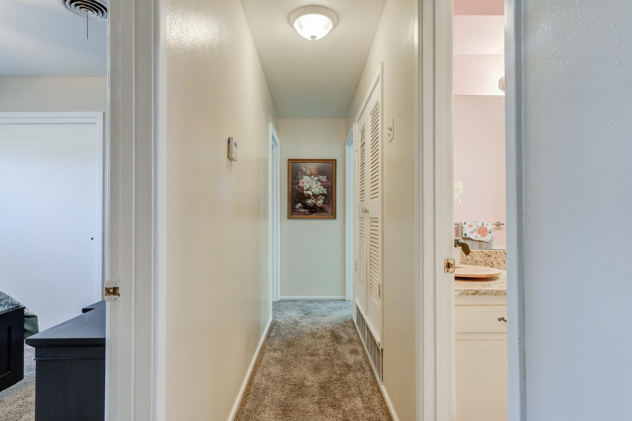 2141 71st Street Lubbock, TX 79412 - Photo 24 of 36 a view of a hallway with wooden floor and a bathroom