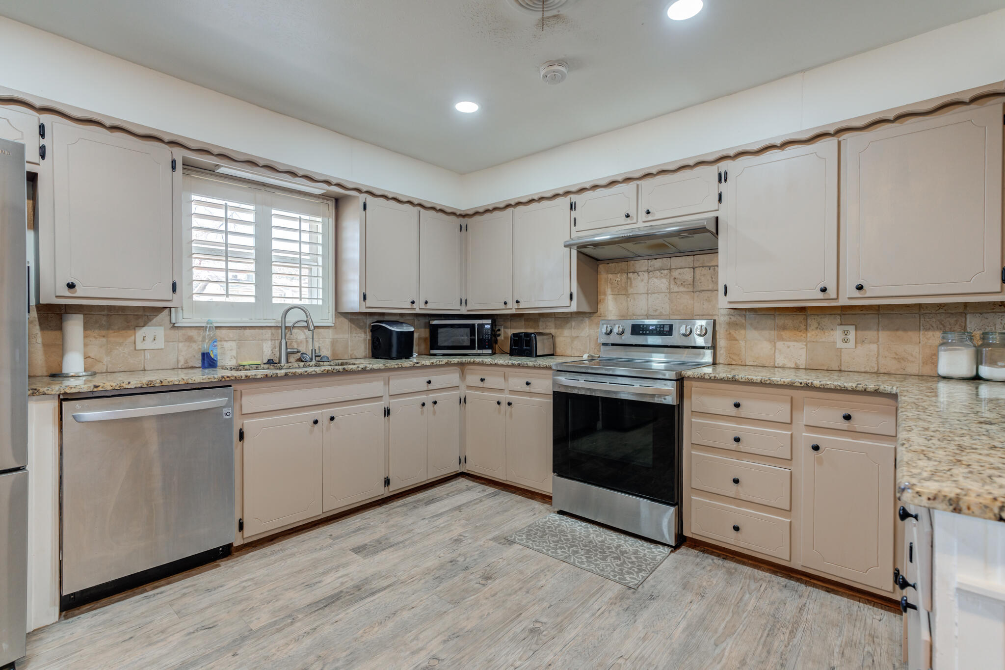 2141 71st Street Lubbock, TX 79412 - Photo 10 of 36 a kitchen with granite countertop white cabinets and white stainless steel appliances