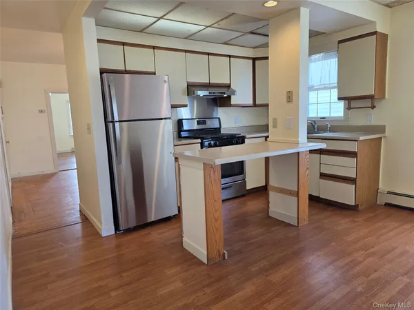 a kitchen with wooden floors and appliances