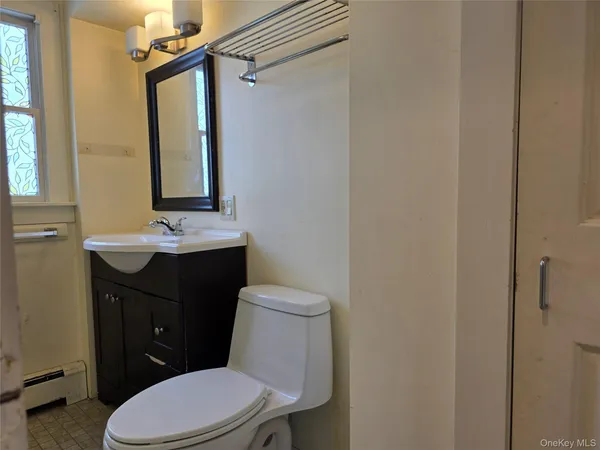 a bathroom with a sink a toilet a mirror and shower